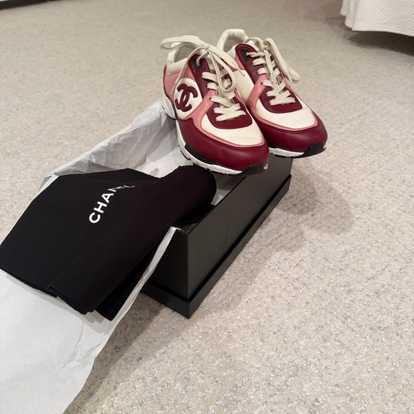 Stylish CHANEL sneakers in burgundy pink and cream. Ideal for casual elegance.